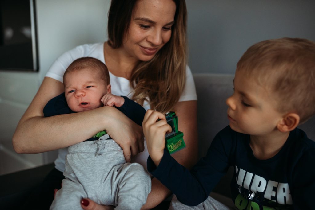 sesja noworodkowa w domu bracia z mamą na kanpie