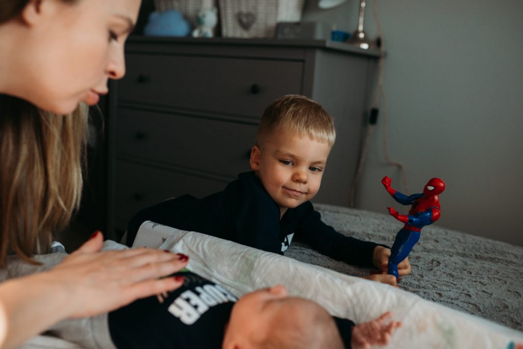 mama przewija noworodka